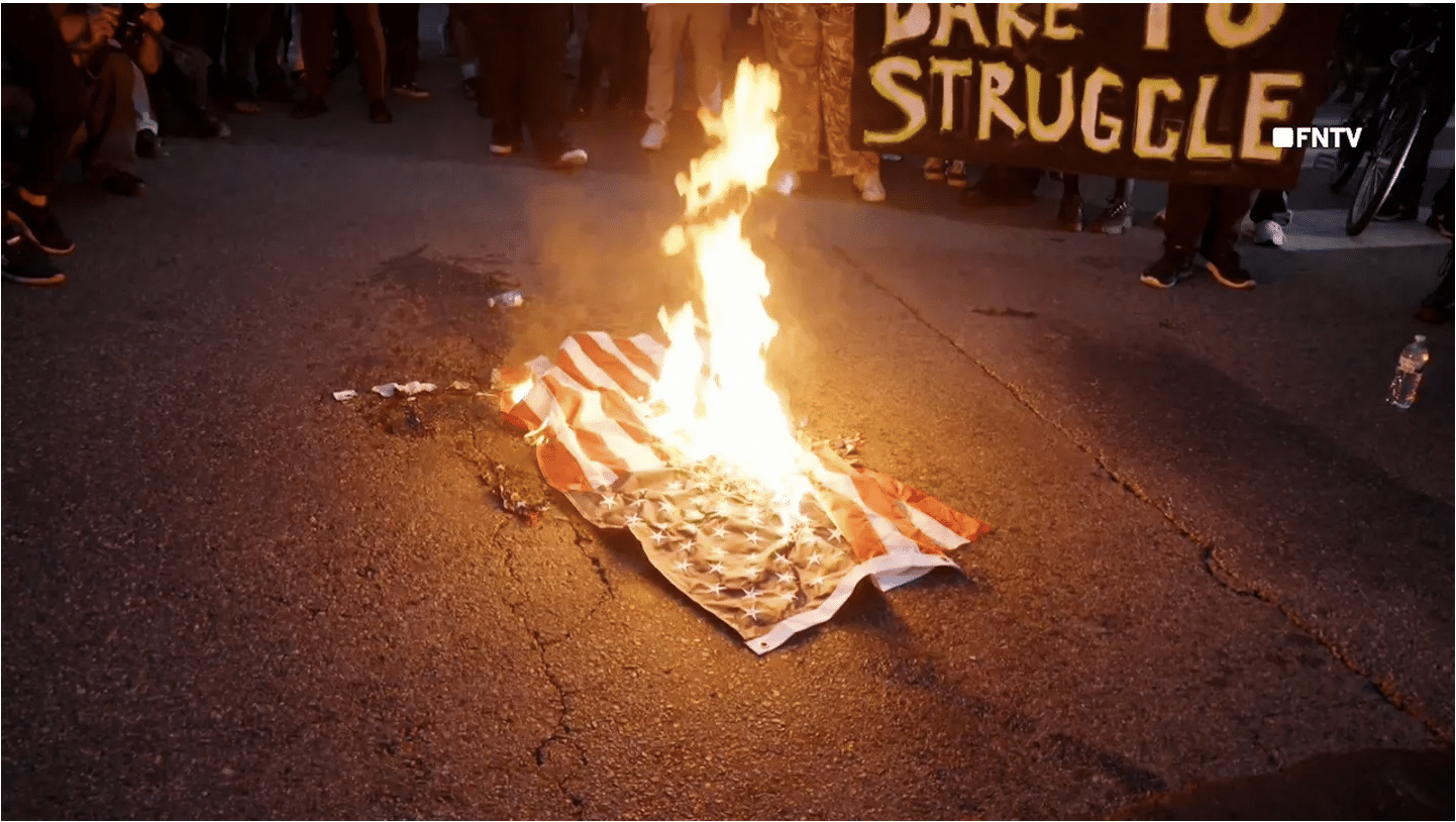 Rioters in Los Angeles seen spitting on and burning American flags